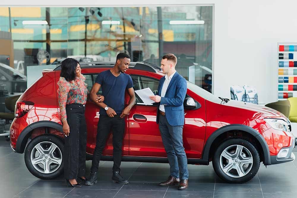 Couple shopping for a new car at a dealership
