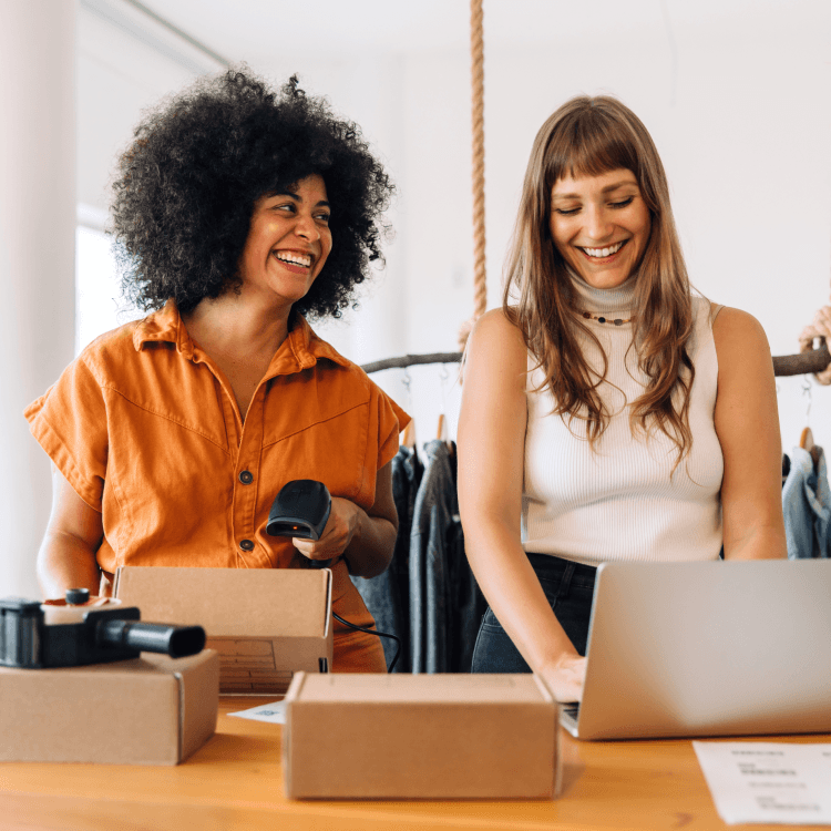 Deux femmes souriantes qui collaborent au travail.