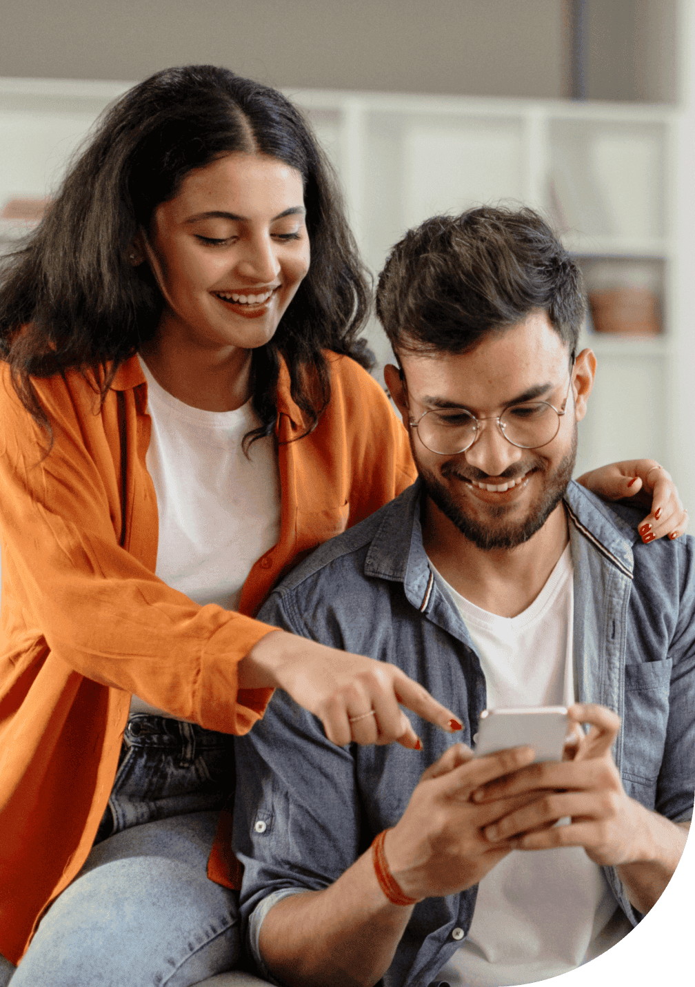 Un couple est heureux d’utiliser leur téléphone intelligent pour obtenir une soumission d’assurance habitation en ligne.