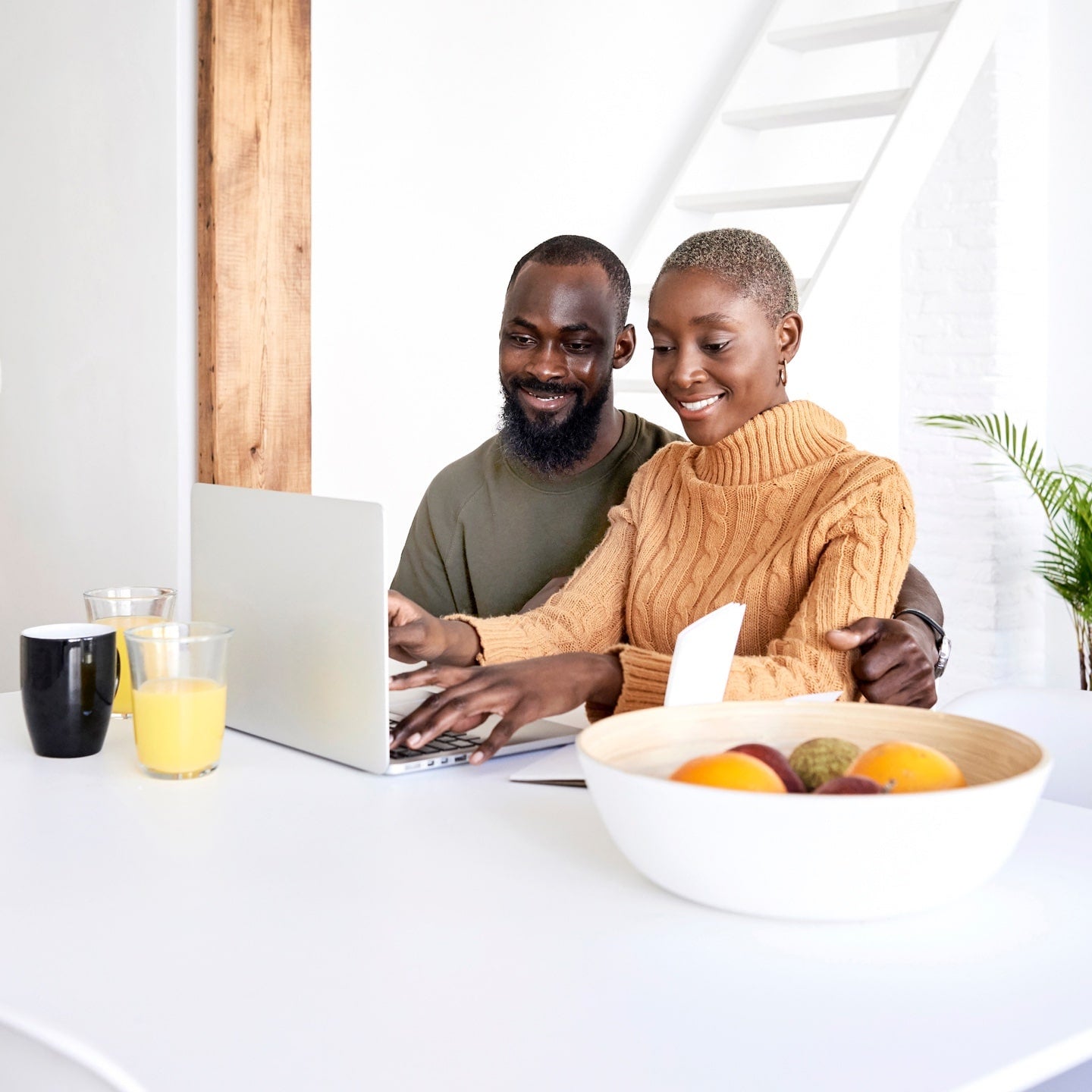 A happy couple getting a condo insurance quote online using their laptop