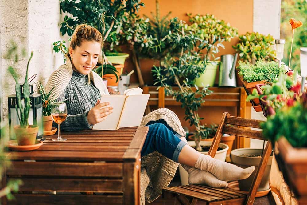 Jeune femme se relaxant sur son balcon