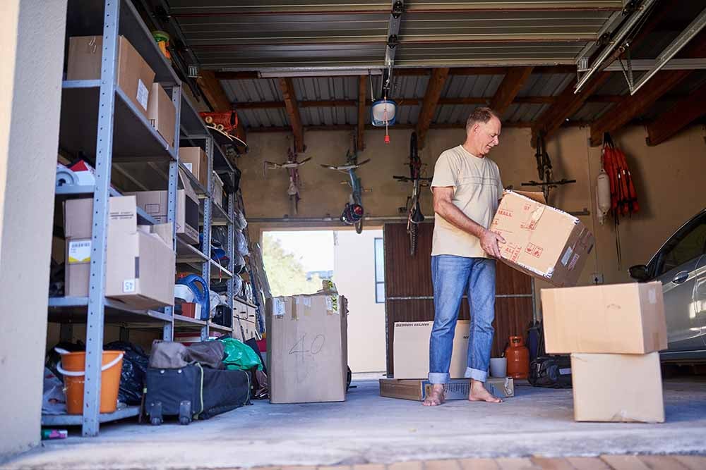 Man sorting boxes in a garage
