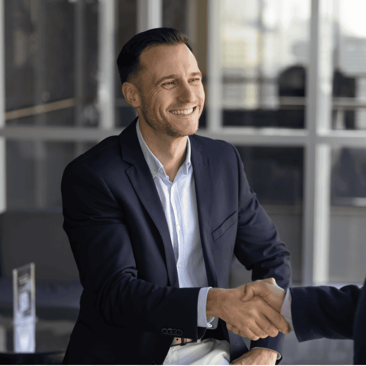 Two people shaking hands in an office.