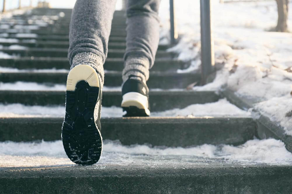 Person's feet walking up icy steps