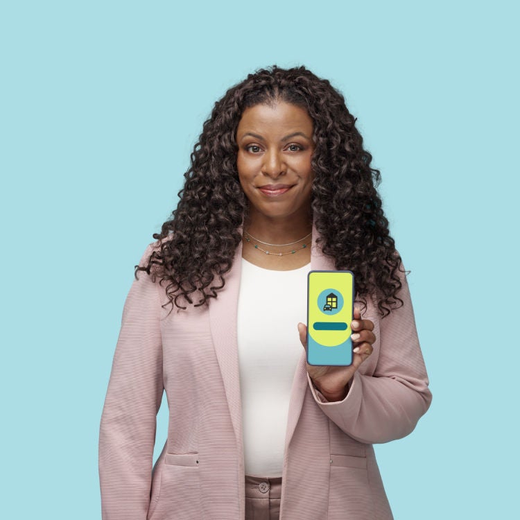 Personne souriante montrant l’écran de son téléphone qui affiche une soumission.
