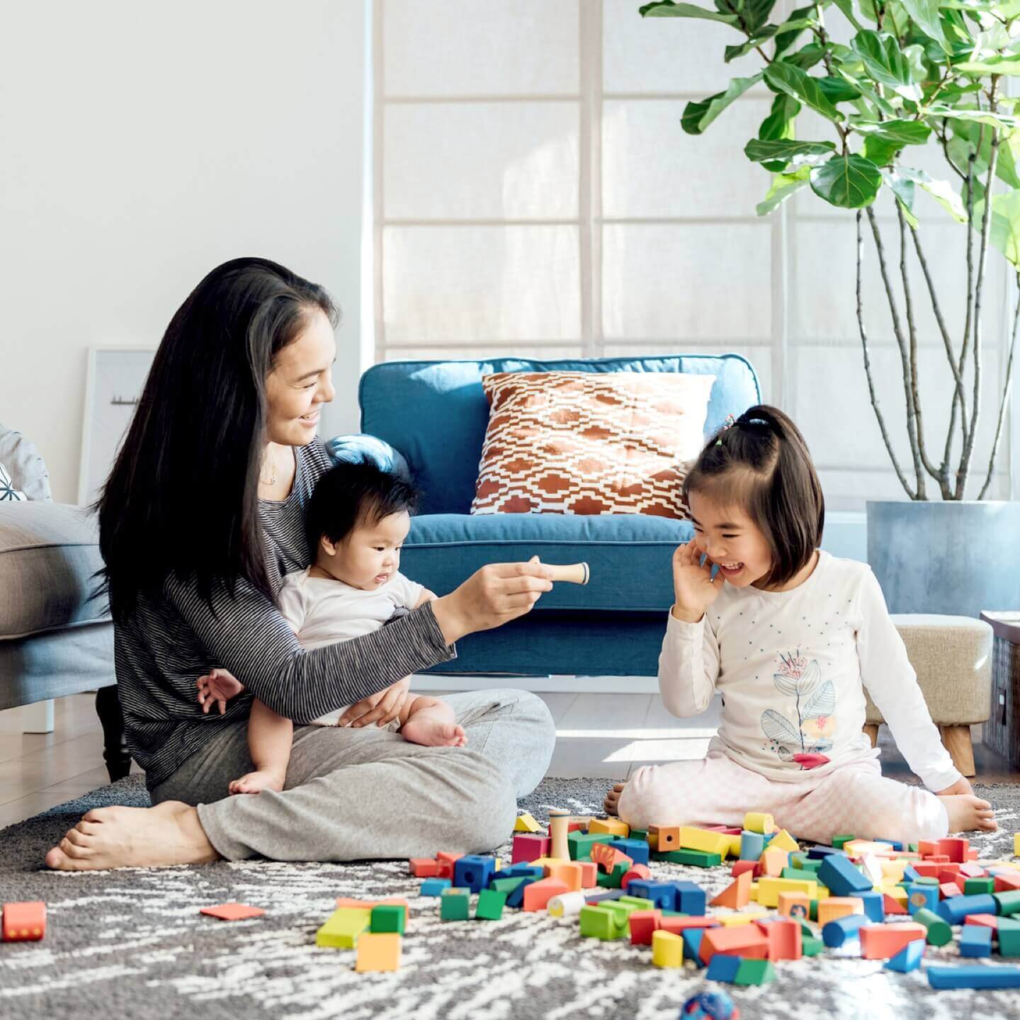 Une mère souriante qui joue avec ses enfants dans son unité de copropriété assurée.