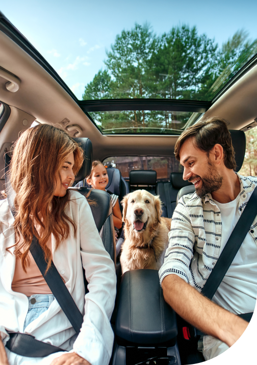 Une famille heureuse avec chien dans une voiture avec assurance en Ontario.