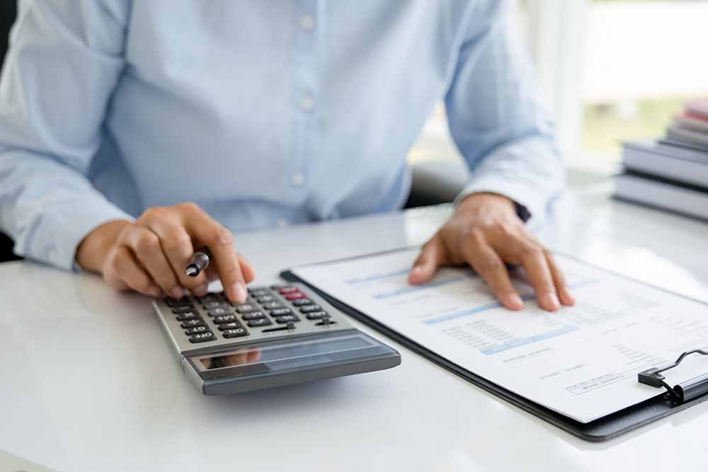 Woman using a calculator to determine her taxes