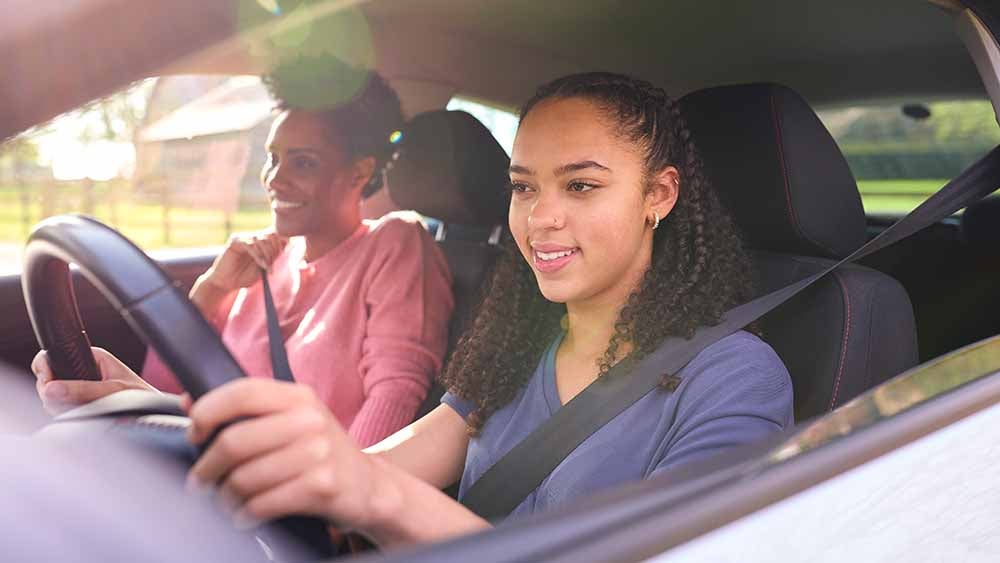 Adolescente qui apprend a conduire avec sa m├¿re