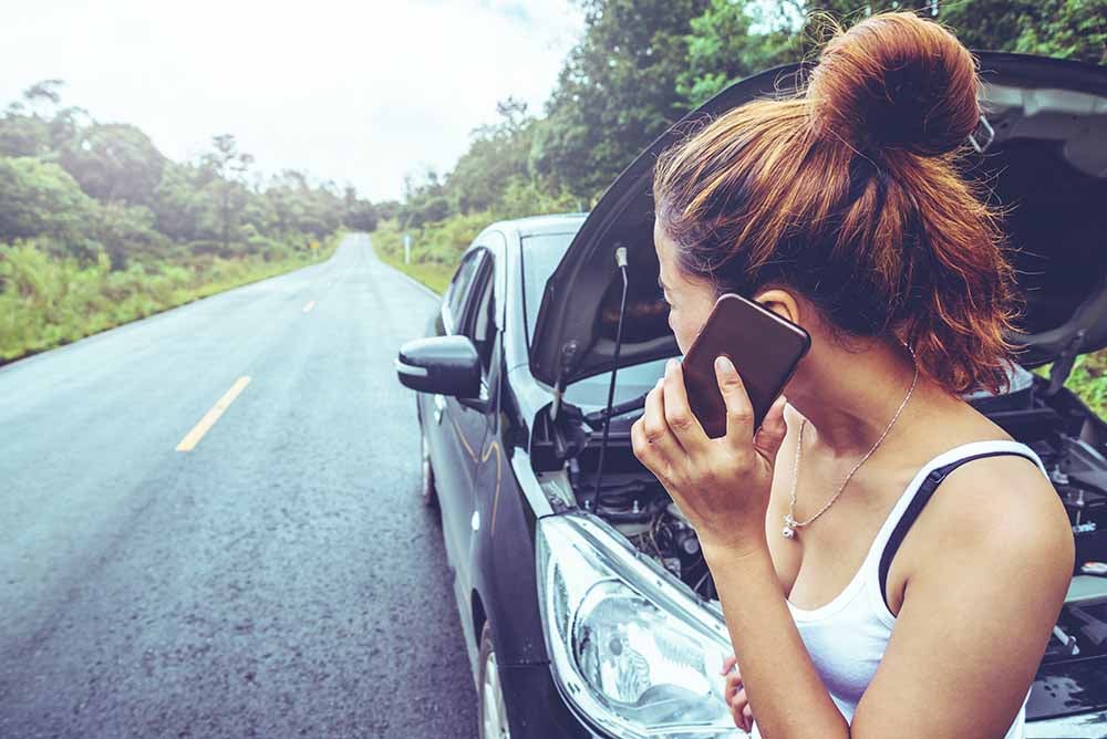 Une femme avec une voiture en panne