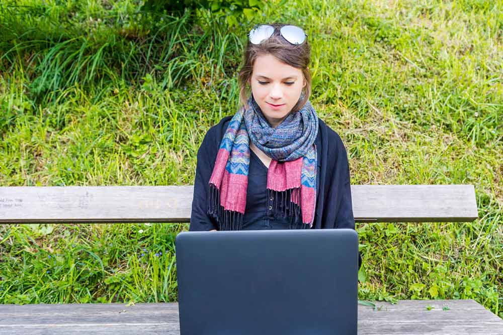 Jeune milléniale sur un portable à l'extérieur