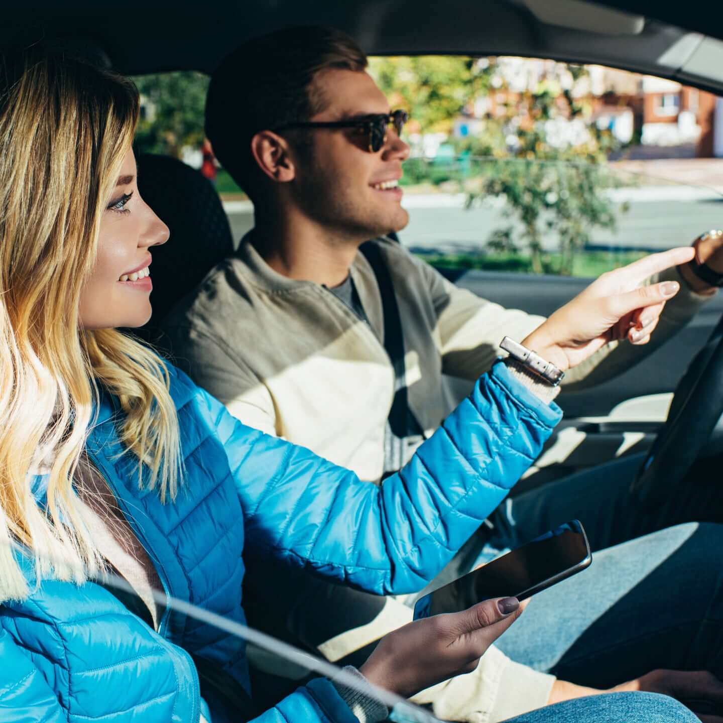 Une femme souriante donne des directions en voiture à son conjoint pour se déplacer dans les rues d’Ottawa.