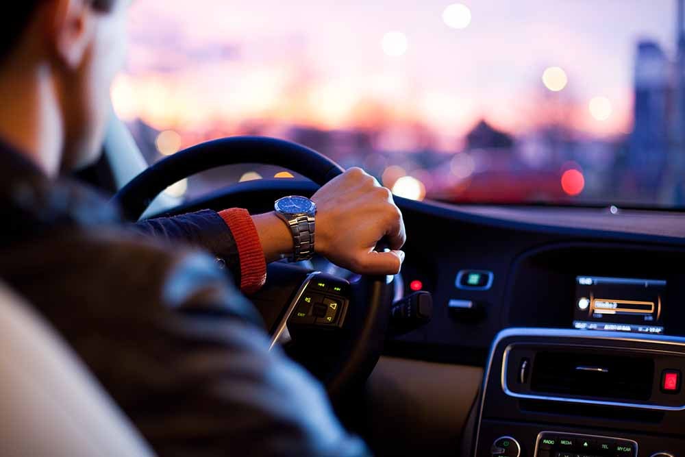 Man driving a car in the evening