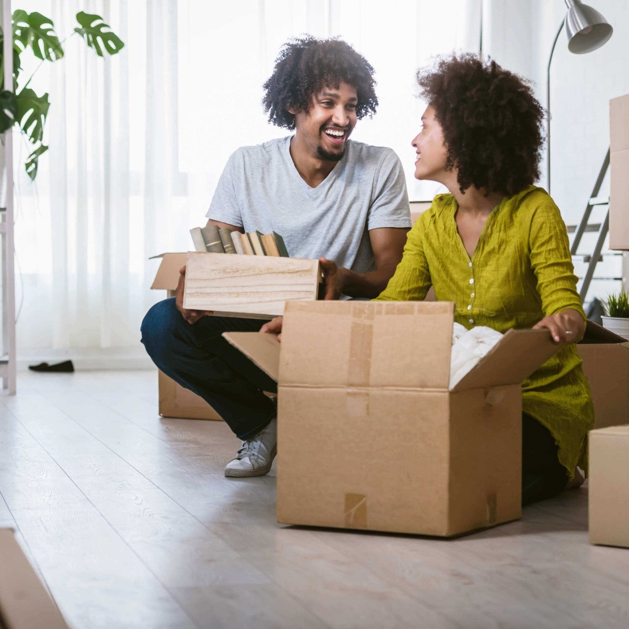 Un couple heureux déballe des cartons pour emménager dans leur appartement.