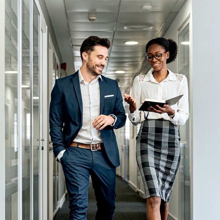 Professionnels dans un bureau, discutant d’assurance habitation et auto.