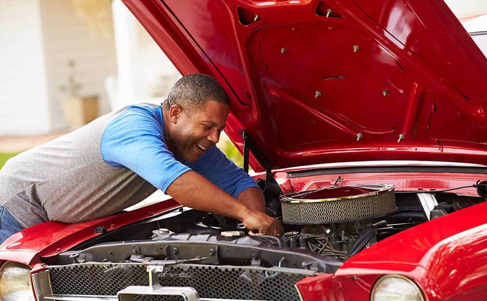Homme qui travaille sur le moteur d'un véhicule
