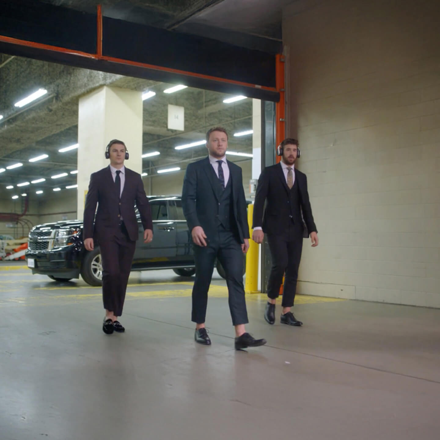 Zach Hyman, Morgan Rielly et Frédérik Gauthier, vêtus de complets, quittent un VUS. Ils marchent dans un couloir avant un match de hockey.