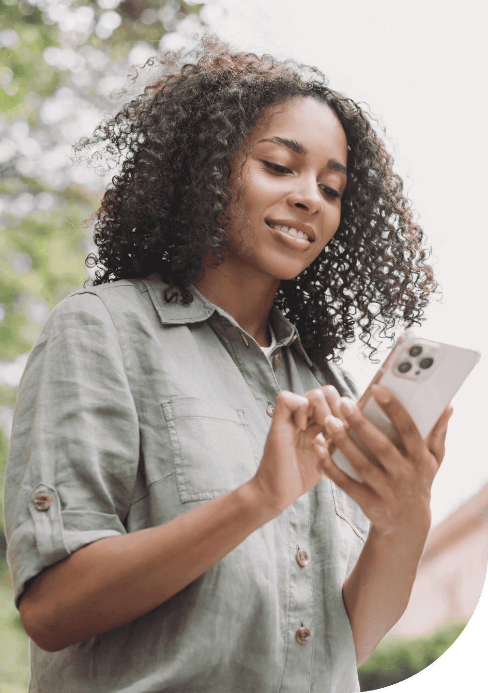 Young woman buying insurance on their mobile phone online while taking a leisurely walk in the park.