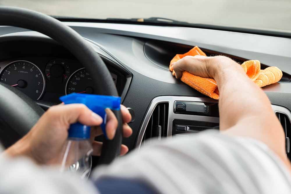 Un homme nettoie l'intérieur d'une voiture