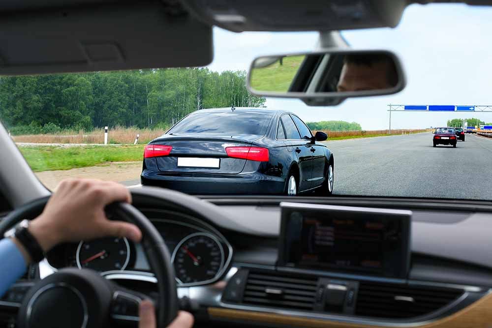 Un homme conduit une voiture sur l'autoroute