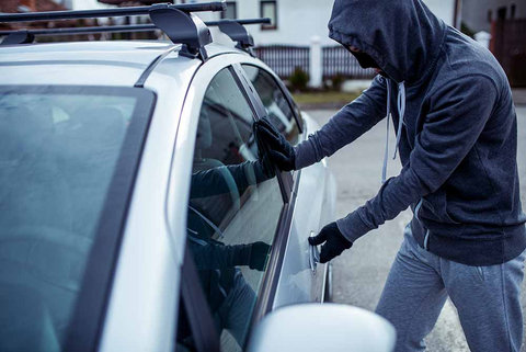 Thief attempting to break into a car