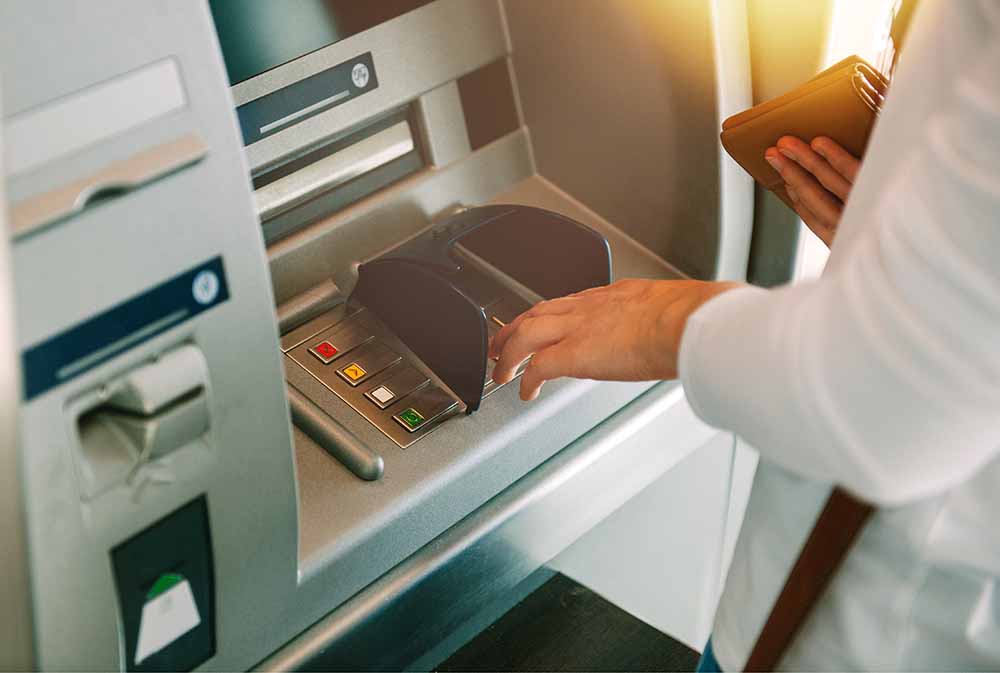 Une femme utilise un guichet automatique bancaire