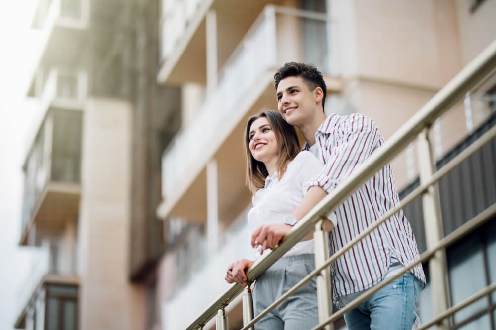 Young couple sitting on a condo balcony