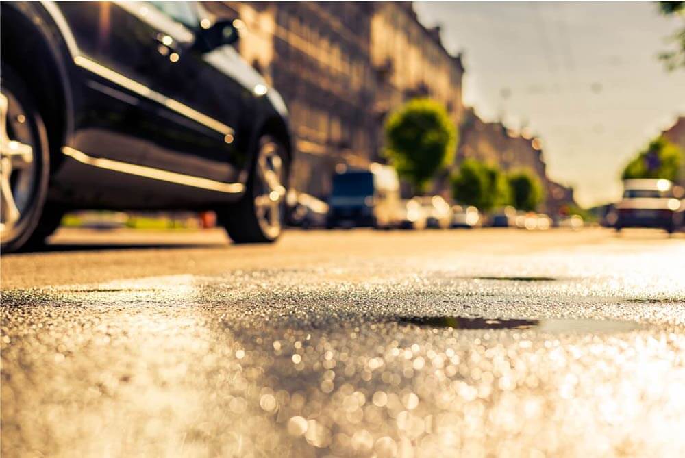 Closeup of the road with a car in the background