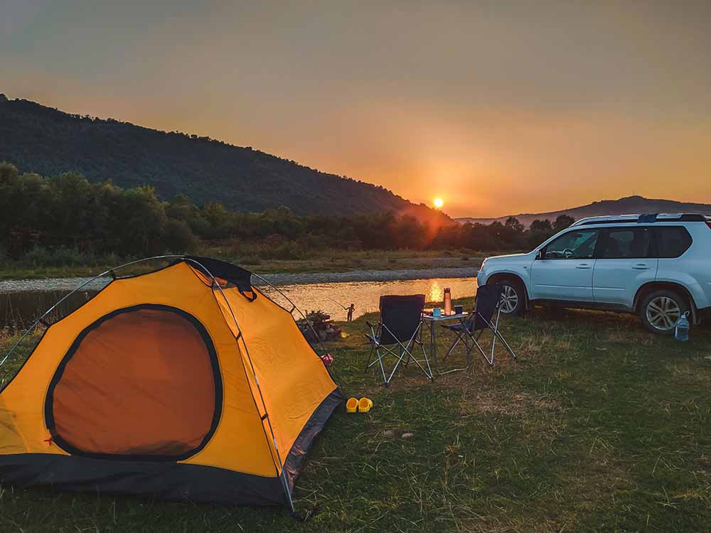 Camping en auto avec un coucher de soleil en arrière-plan