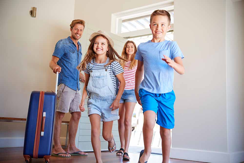 Une jeune famille arrive à une résidence de vacances