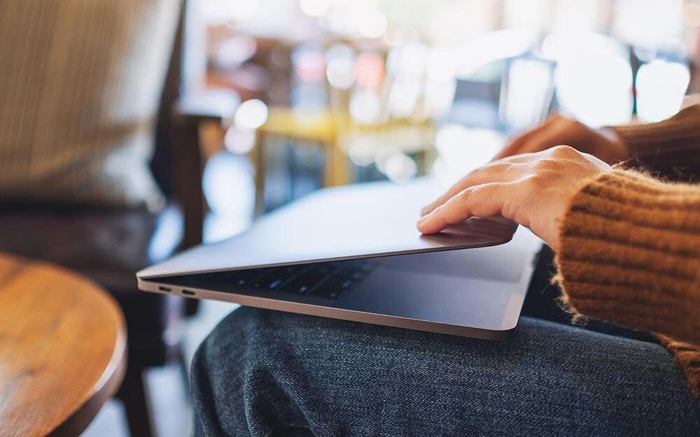 Person closing a laptop