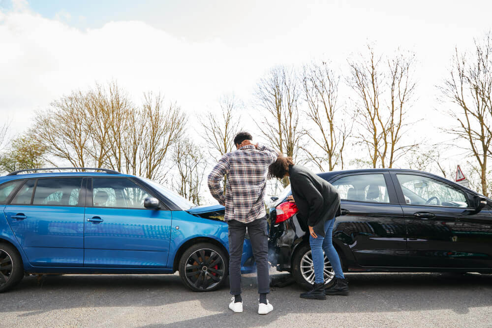 Man and woman inspect car after accident in Ontario