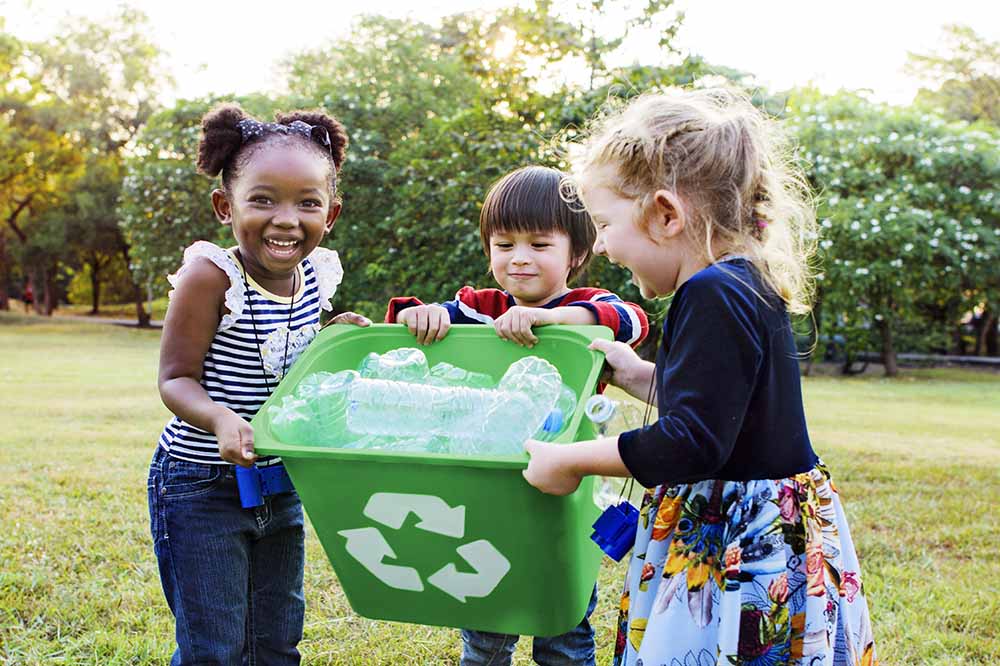 Un groupe d’enfants près d’un bac à recyclage