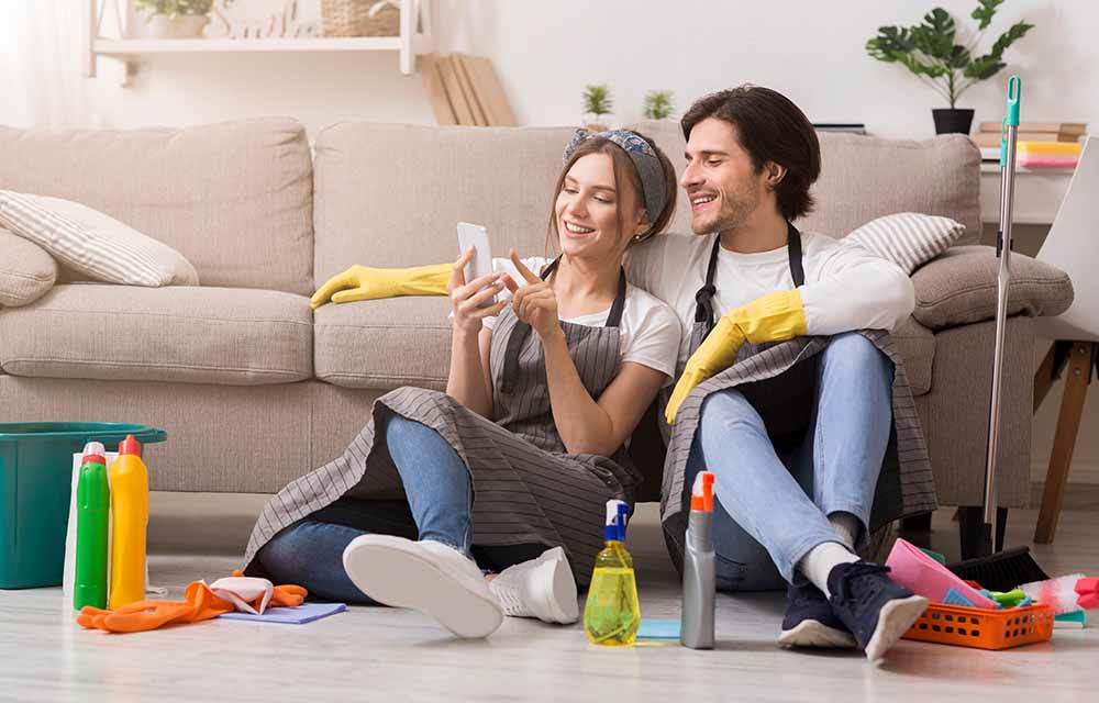 Jeune couple faisant le ménage de printemps dans leur appartement
