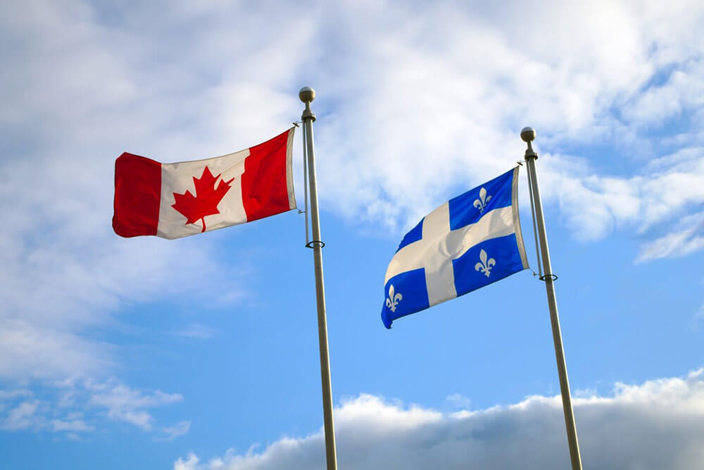 Quebec and Canadian flags waving in the wind