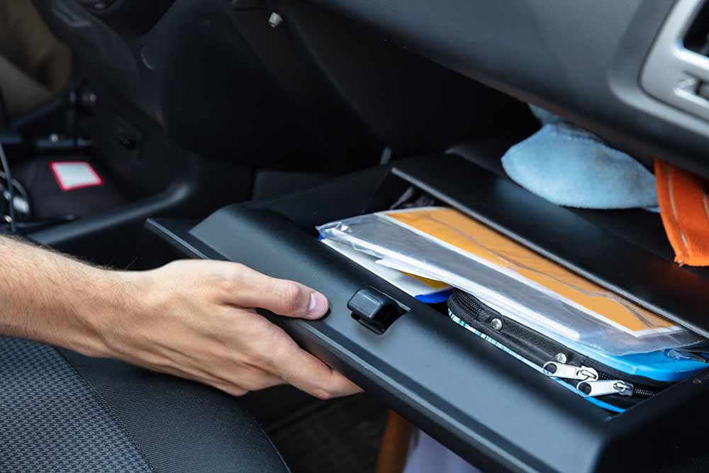Driver opening a car glovebox