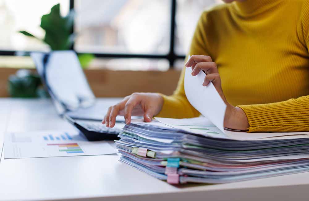 Woman sorting through financial paperwork at a desk