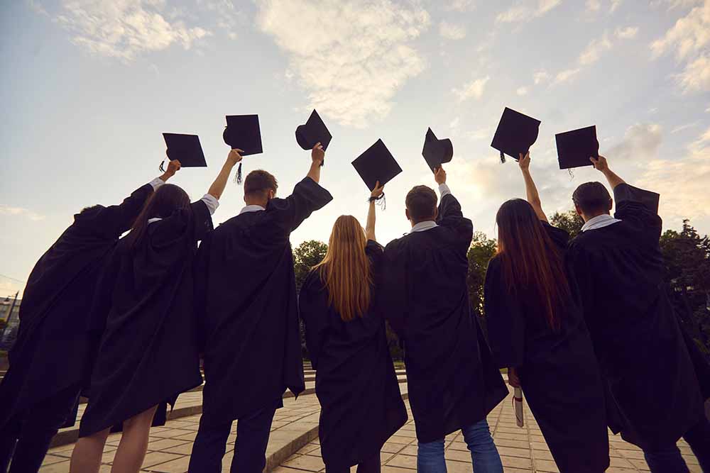 College graduates raising their caps in the air