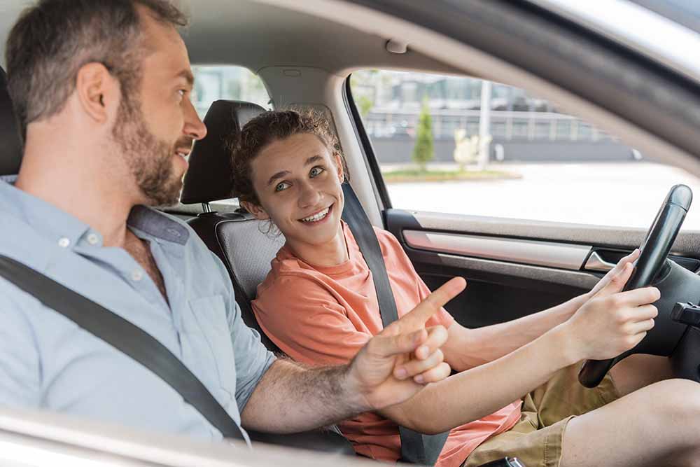 Jeune adulte avec un moniteur de conduite automobile