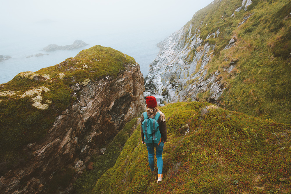 Female traveller backpacking on a cliff