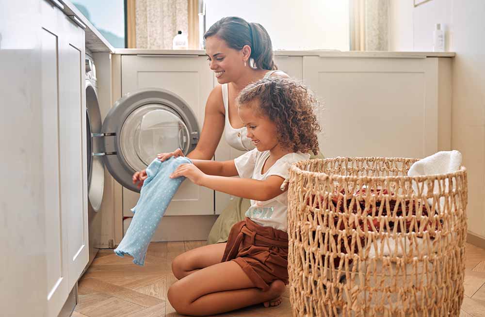 Young girl helping her mother do the laundry