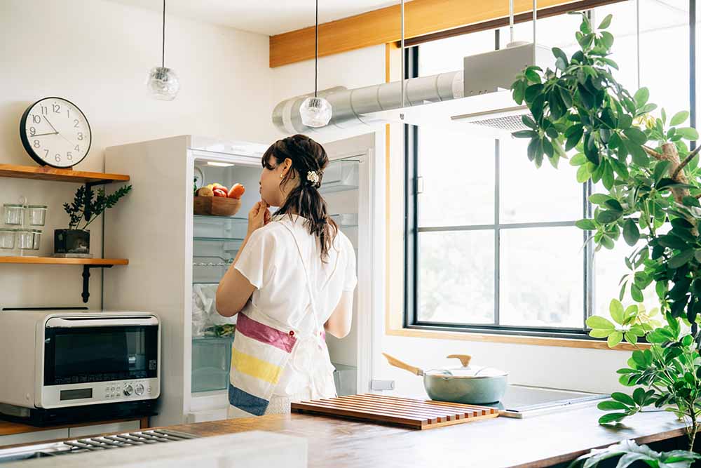 Woman examining the inside of her fridge