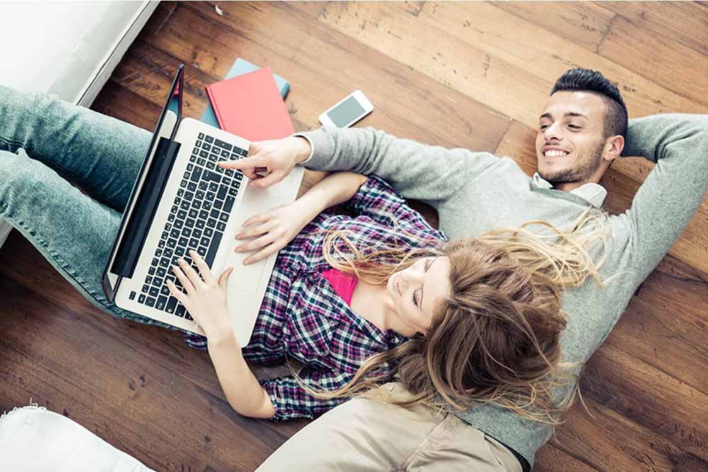 Man and woman on the floor with a laptop open