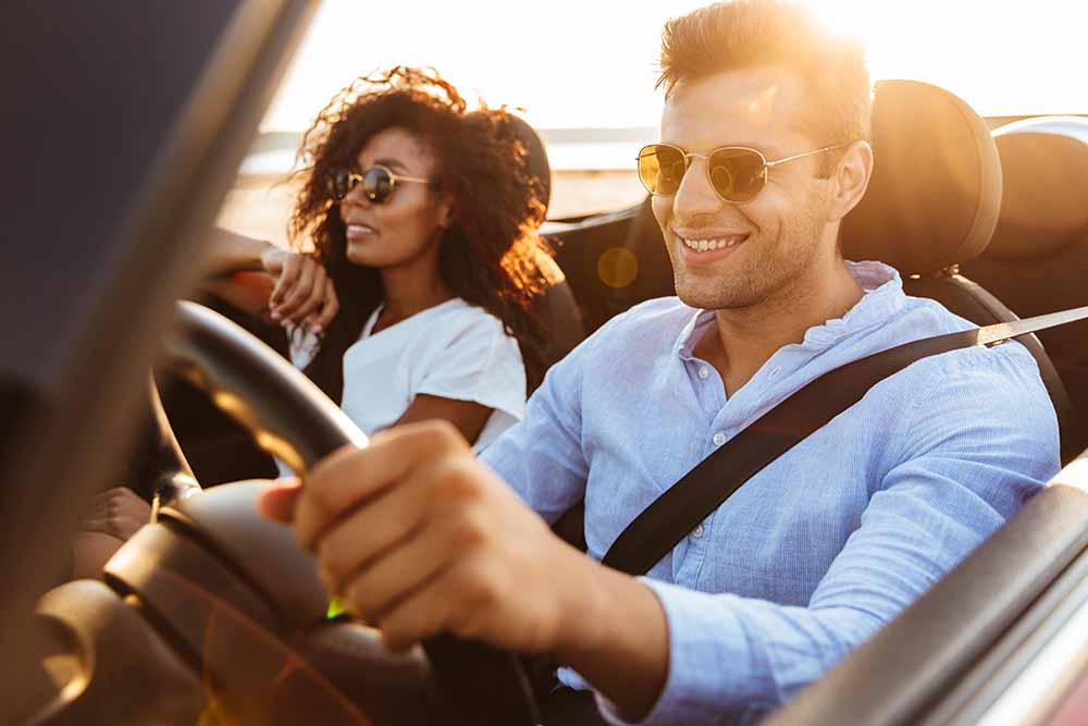 Un homme et une femme dans une voiture décapotable