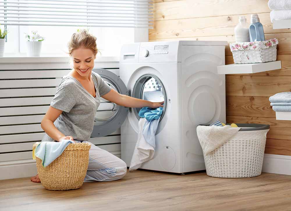 Woman loading laundry into a washing machine