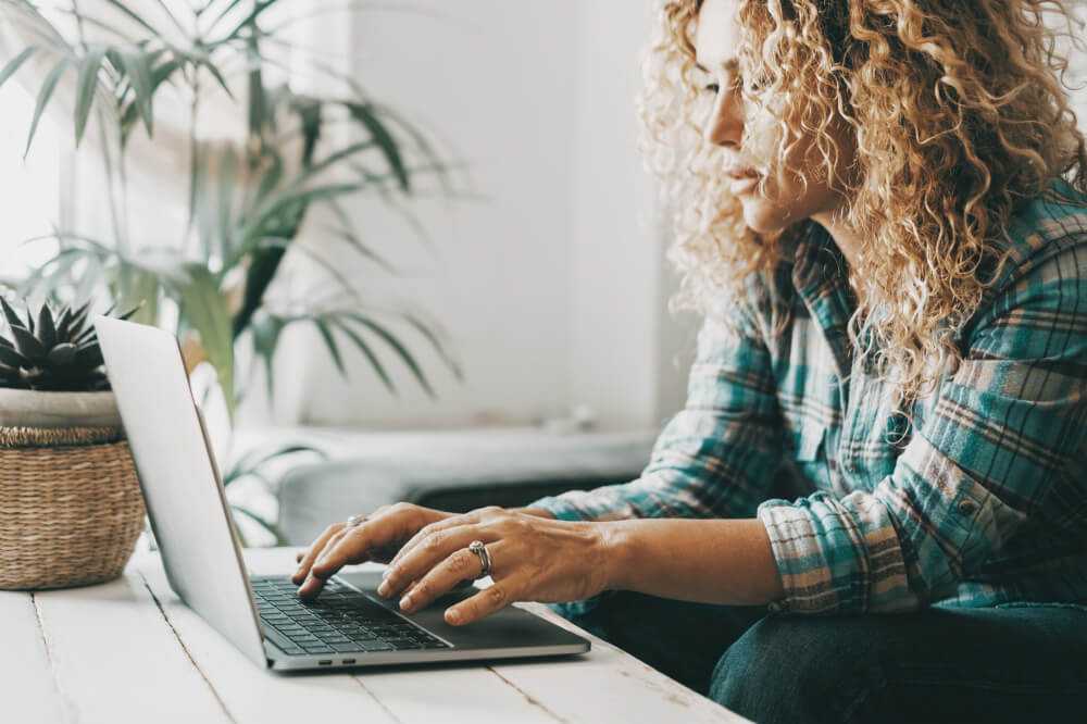 People working on computer at home. One woman write and use laptop with internet online connection. Modern female use notebook and work. Indoor leisure activity and technology. Searching on web