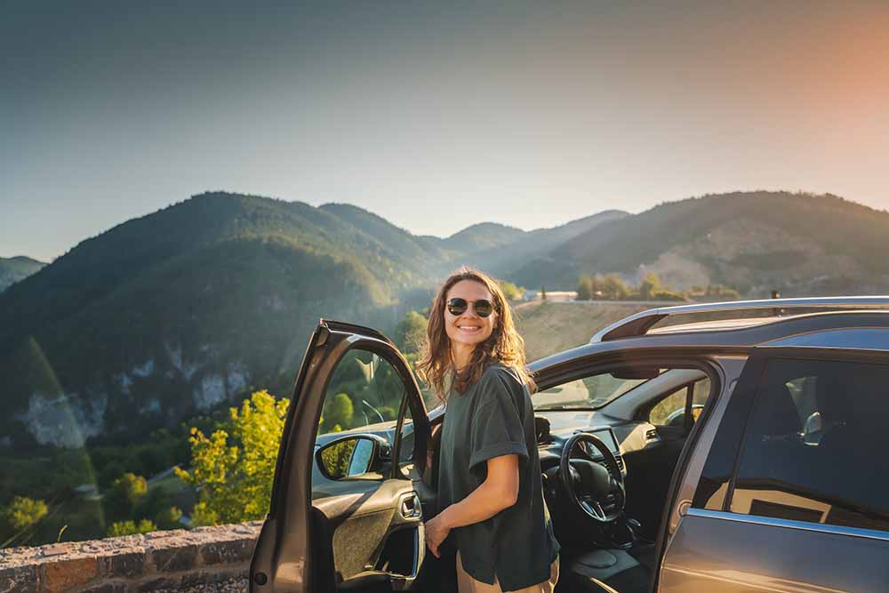 Woman standing by an open car door