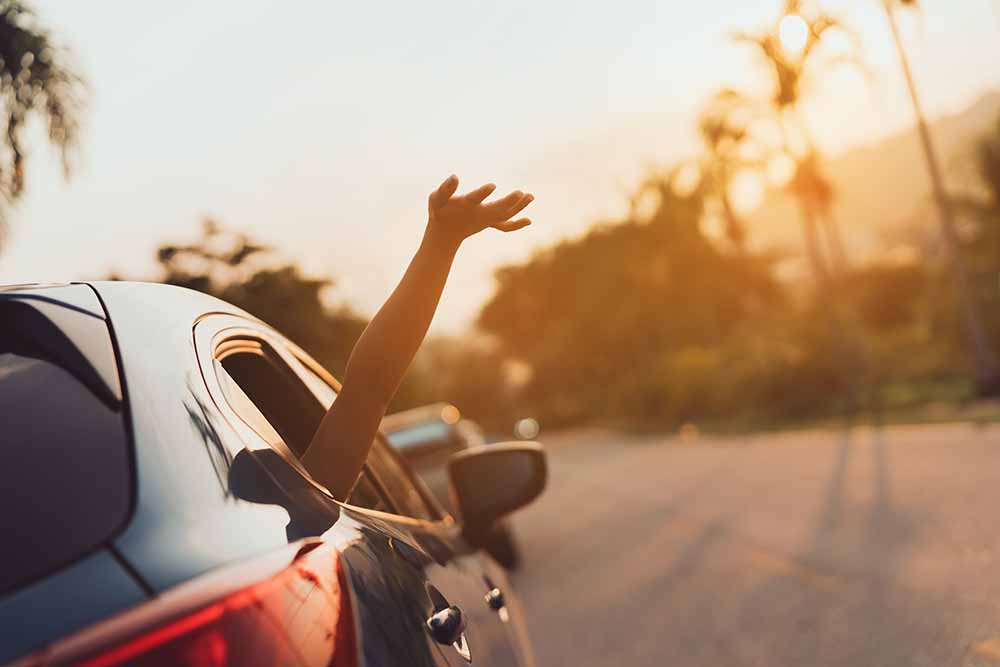Person waving out of a car window