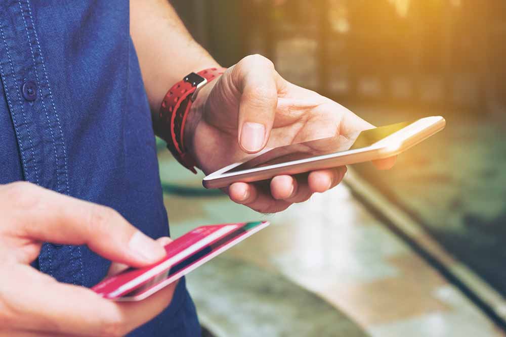 Homme tenant une carte de crédit et un téléphone intelligent
