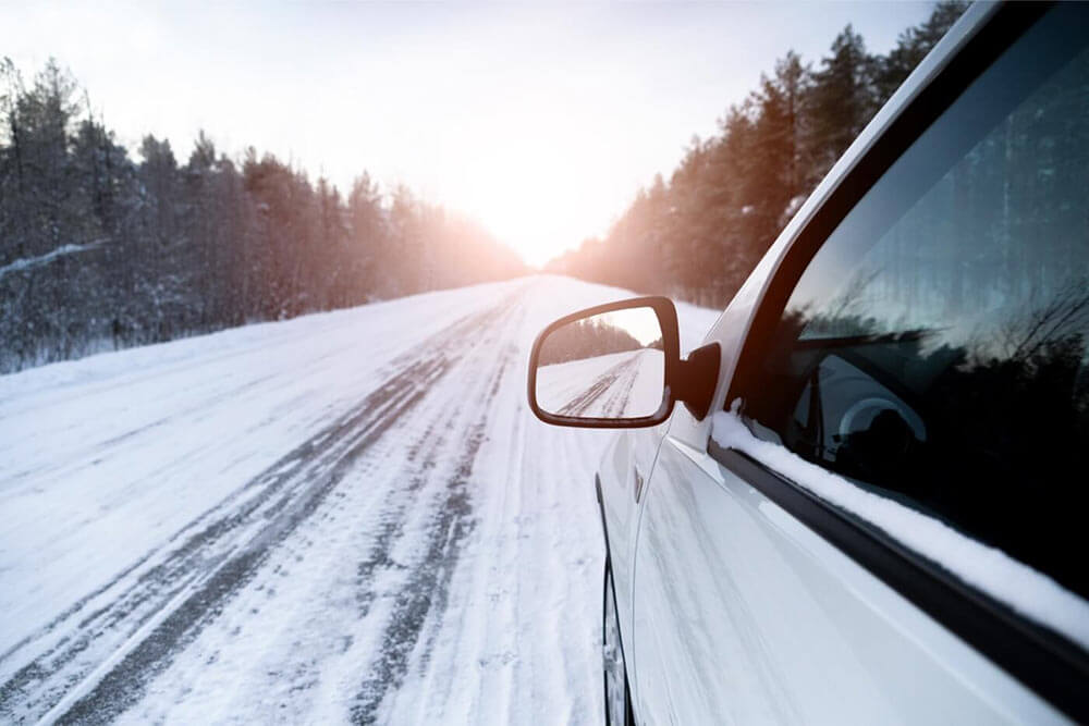 Drivers side of car on a snowy road